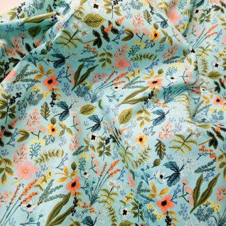 tissu imprimé Amalfi fleurs de Printemps de Rifle Paper Co sur un fond bleu aqua un foisonnement de fleurs champêtres aux couleurs pastels rose, bleu, jaune