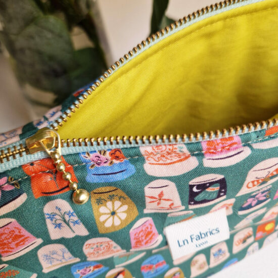 trousse de toilette de voyage ou à projets en tissu imprimé dès à coudre multicolores sur fond vert la doublure est jaune pickle en coton