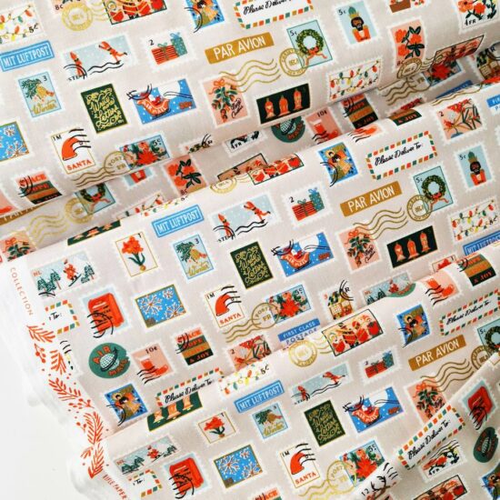 tissu rifle paper co holiday classics imprimé noel fond beige timbres multicolores parfait pour les cousettes de noël