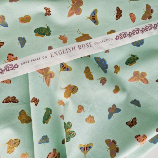 Tissu coton imprimé papillons Rifle paper Co frais et léger sur ce fond vert menthe envolée de papillons doré bleu, vert, terracota