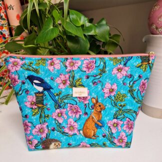 trousse molletonnée en coton imprimé floral et animaux de la forêt sur un fond bleu turquoise